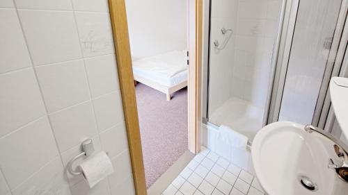 a small bathroom with a toilet and a shower at Hotel Victoria in Weil am Rhein