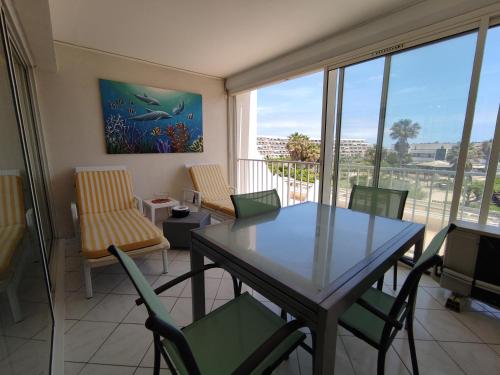 une salle à manger avec une table et des chaises et une fenêtre dans l'établissement Appartement 204, Natura Beach au village naturiste, au Cap d'Agde