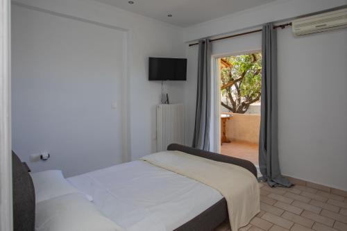 a bedroom with a bed and a sliding glass door at dreamcatcher in Anavissos