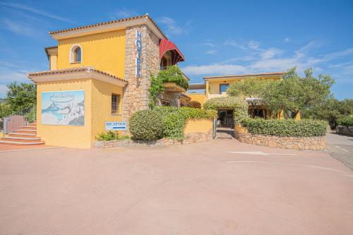 a yellow building with a sign on the side of it at Hotel Lu Pitrali in San Teodoro