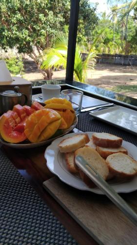 a table with two plates of bread and fruit at Matteo's hus VILLA RENTAL in Zamboanguita