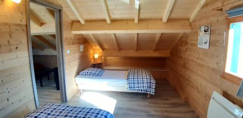 a small room with two beds in a cabin at L étincelle du Manon in Lajoux