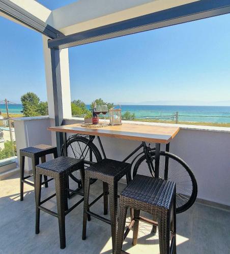 a table and chairs on a balcony with the ocean at Морска къща ЕММА in Ofrínion