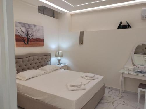um quarto branco com uma cama e um espelho em ATHENS City Center Historical Area em Atenas