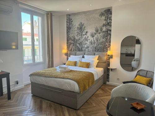 een slaapkamer met een bed, een spiegel en een stoel bij PALAIS DES FESTIVALS à 3 min - Croisette - Plage in Cannes