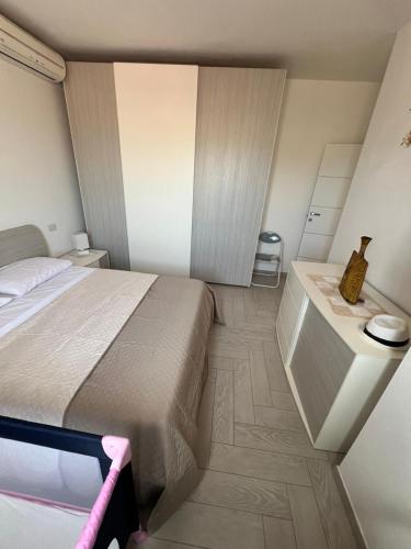 a small bedroom with a bed and a table at Amicizia in Valledoria