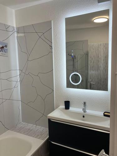 une salle de bain avec un lavabo et un miroir dans l'établissement appartementT2 à 2 pas du circuit, au Mans