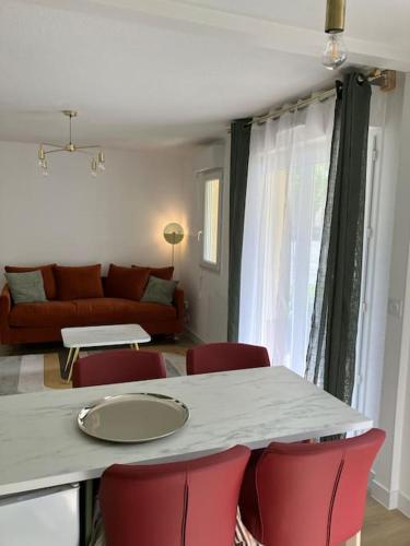 un salon avec une table et des chaises rouges dans l'établissement appartementT2 à 2 pas du circuit, au Mans