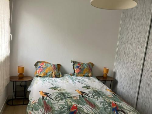 a bedroom with a bed with birds on it at appartementT2 à 2 pas du circuit in Le Mans