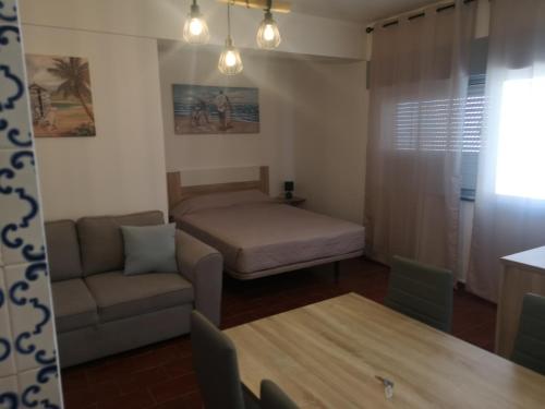 una pequeña sala de estar con sofá y cama en Panorama Apartament, en Portimão