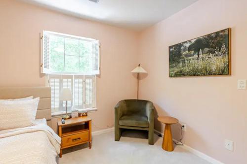 a bedroom with a chair and a bed and a desk at The Halcyon Days North Charleston in Charleston