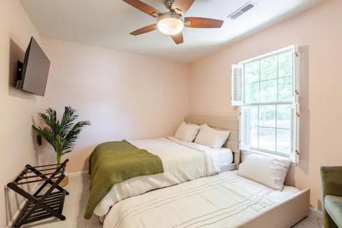 a bedroom with a bed and a ceiling fan at The Halcyon Days North Charleston in Charleston