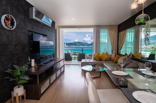 a living room with a couch and a tv at Patong Kalim Unparalleled Sea View B&B Resort in Patong Beach