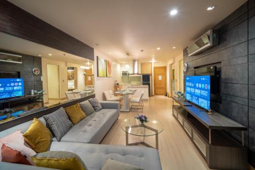 a living room with a couch and a flat screen tv at Patong Kalim Unparalleled Sea View B&B Resort in Patong Beach