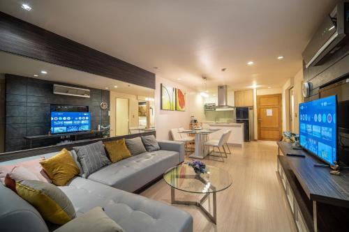 a living room with a couch and a table and a tv at Patong Kalim Unparalleled Sea View B&B Resort in Patong Beach