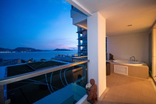 a balcony with a bath tub and a sink at Patong Kalim Unparalleled Sea View B&B Resort in Patong Beach
