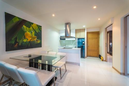 a kitchen and dining room with a glass table and chairs at Patong Kalim Unparalleled Sea View B&B Resort in Patong Beach