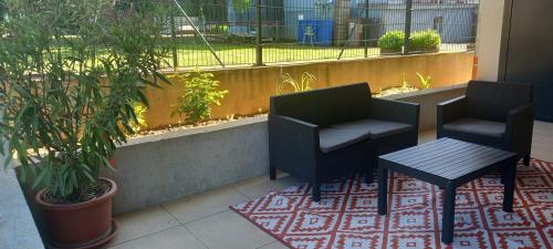 a patio with two chairs and a table on a rug at Le jardin de Clémentine in Wingersheim