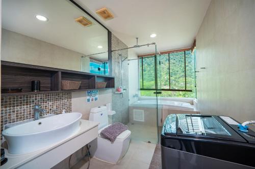 a bathroom with a sink and a toilet and a tub at Patong Kalim Unparalleled Sea View B&B Resort in Patong Beach