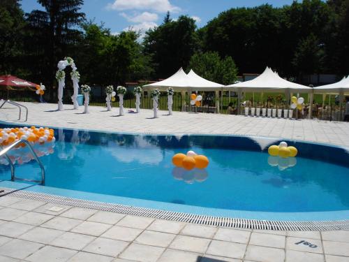 a swimming pool with balloons and tables and tents at Kovanlika Hotel in Razgrad