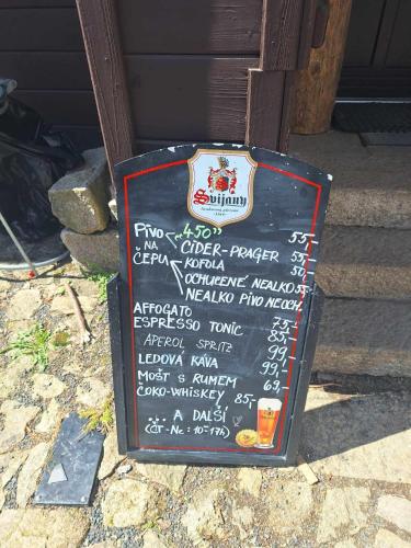 a chalkboard sign sitting on the side of a building at Dvouložnicový apartmán Sluníčko in Zásada