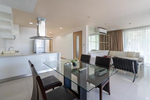 a dining room and living room with a glass table at Patong Kalim Unparalleled Sea View B&B Resort in Patong Beach