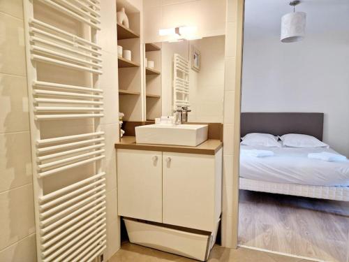 a bathroom with a sink and a bed in a room at Maison du Terral in Saint-Côme-dʼOlt