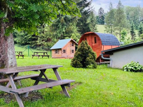 a picnic table and a barn in a field at Apartmán na sjezdovce in Sedloňov