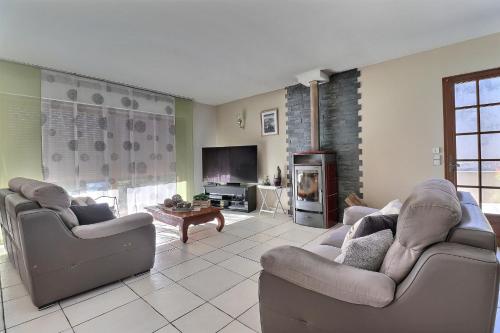 a living room with two couches and a fireplace at Grande maison avec jardin in Sarrancolin
