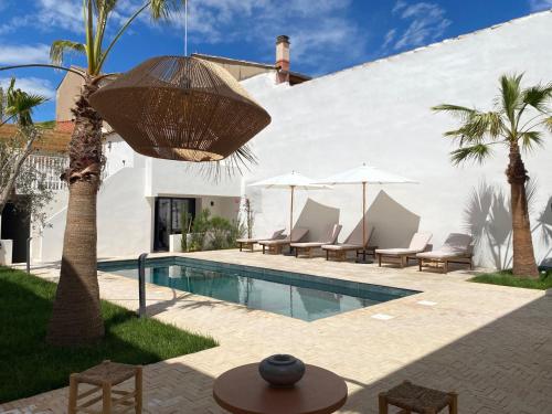 - une piscine avec des chaises et des parasols à côté d'une maison dans l'établissement La Maison De Ville - Piscine - SPA, à Sète