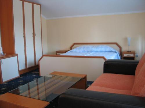 a bedroom with a bed and a couch and a coffee table at Kovanlika Hotel in Razgrad