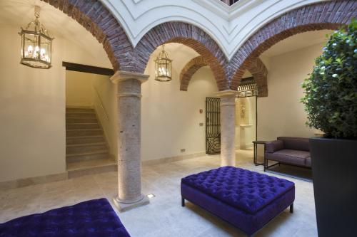 a living room with a purple ottoman in a building at Hotel Claude Marbella in Marbella