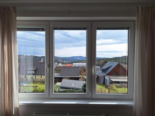 a window with three views of a city at Dvouložnicový apartmán Sluníčko in Zásada