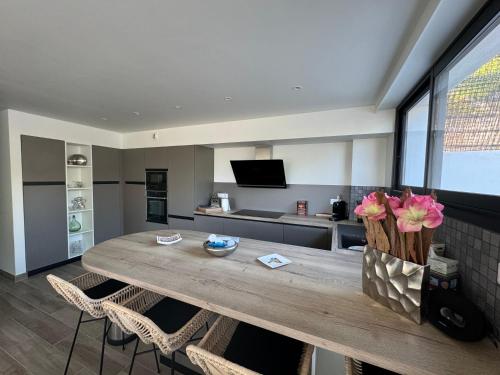 une grande table en bois dans une cuisine avec des chaises dans l'établissement Proche porticcio, Coup de cœur asuré,Appartement de standing, rez de villa 6 couchages, climatisé à 150m de la plage, terrains de tennis, à Grosseto-Prugna