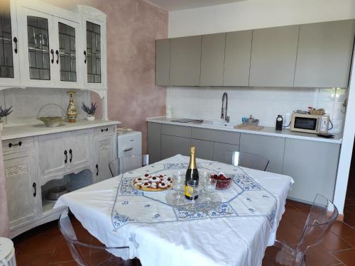 a kitchen with a table with a bottle of wine and a pizza at La casa di Giada, villetta indipendente con wi-fi e parcheggio gratuiti in Poggi