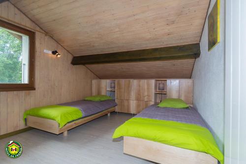 deux lits dans une chambre aux murs en bois dans l'établissement Ôdétente, à Brié-et-Angonnes