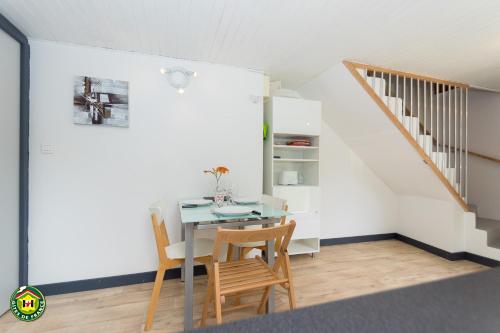 une salle à manger avec une table et des chaises et un escalier dans l'établissement Ôdétente, à Brié-et-Angonnes