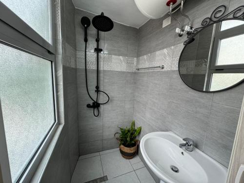 a bathroom with a tub and a sink and a mirror at Double17 Apartaments in Gjirokastër