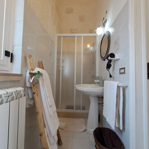 a white bathroom with a sink and a shower at Trulli di Rosa in Locorotondo