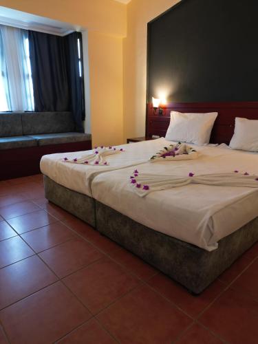 a bedroom with a large bed with flowers on it at LEMAS SUITE HOTEL in Side