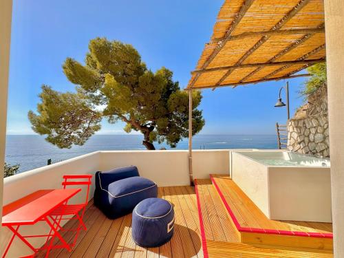 taras ze stołem i krzesłami oraz widokiem na ocean w obiekcie Villa Bossa w Amalfi