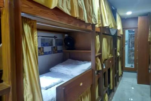 a room with two bunk beds with yellow curtains at Kalina Asian Dormitory in Mumbai