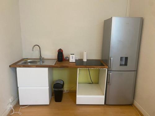 une cuisine avec un évier et un réfrigérateur dans l'établissement T2 proche de la gare et du centre-ville nouveau proprio, à Besançon