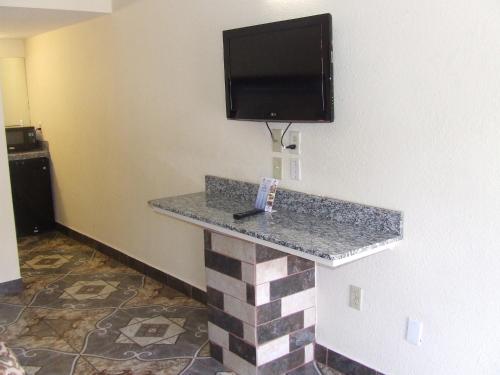 a counter in a hotel room with a tv on a wall at Americas Best Value Inn Beaumont in Beaumont