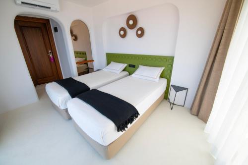 a bedroom with two beds and a door at Hotel Begonvil in Kas