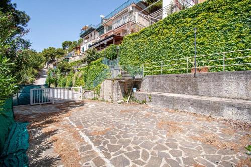een stenen loopbrug met een trap naast een gebouw bij Acciaroli parco baia dei pini lotto a piccola in Acciaroli