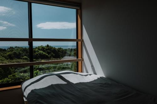 Postel nebo postele na pokoji v ubytování Årc yakushima