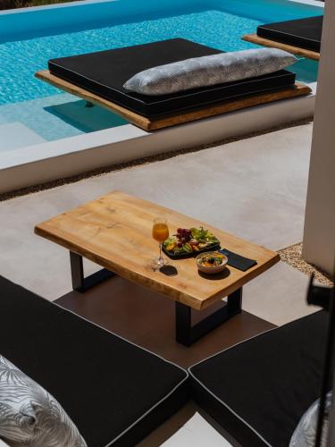 a table with a plate of food and a glass of wine at Youtopia Ios Villas in Ios Chora