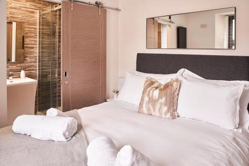 a bedroom with a large white bed with a sink at Harbour Breeze - On Torquay's iconic marina with hot tub in Torquay