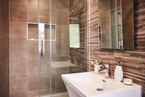 a bathroom with a sink and a shower at Harbour Breeze - On Torquay's iconic marina with hot tub in Torquay